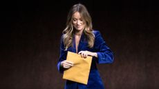 Olivia Wilde opens up envelope on stage at CinemaCon