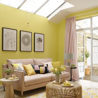 modern yellow living room with pink sofa skylights and patio doors