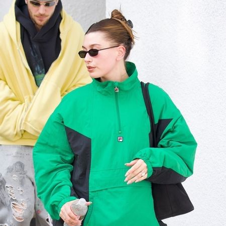 Hailey Bieber wearing a green windbreaker with bike shorts 