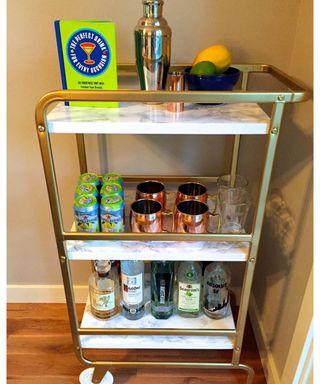 A DIY bar cart made from Ikea bar stand, gold spray paint and marble contact paper