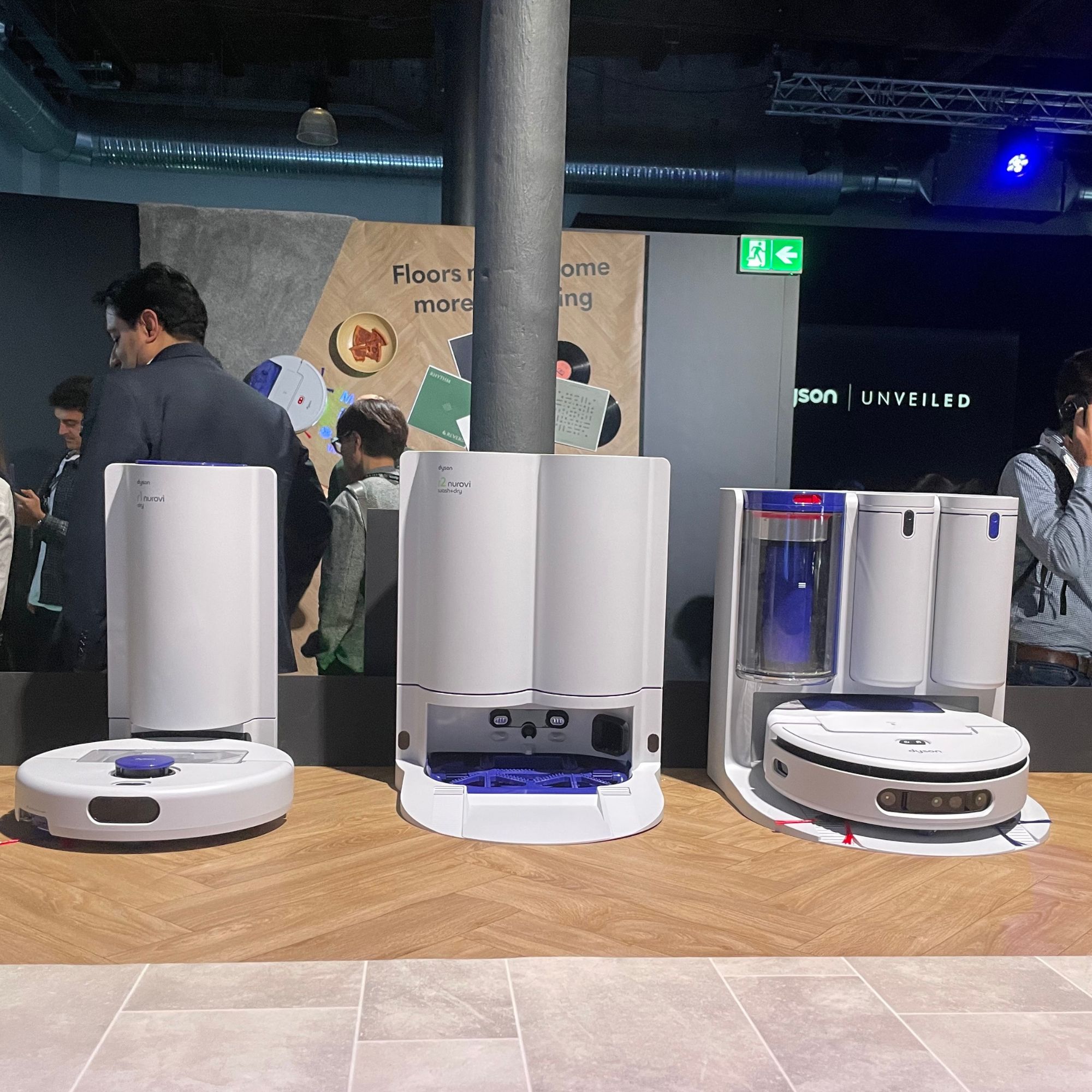 White Dyson Nurovi robot vacuums sitting on wood effect flooring