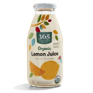 A beige bottle of lemon juice with yellow lemon juice design, multicoloured tree and green logo