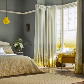 bedroom with yellow armchair and wooden flooring