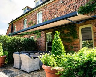 patio awning with garden furniture and topiary