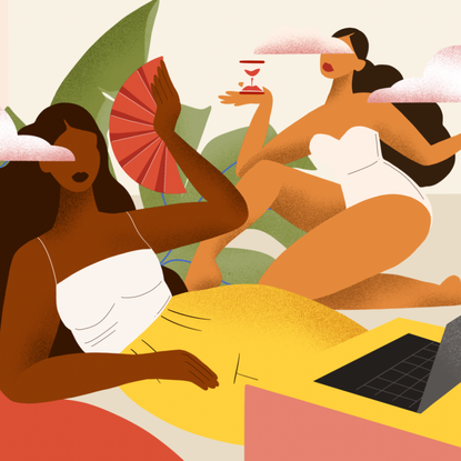 Two women in an office using a fan