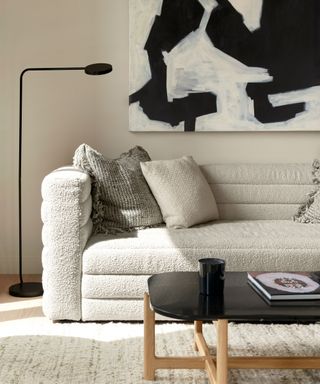 A gray textured sofa and black-and-white piece of art in a studio apartment