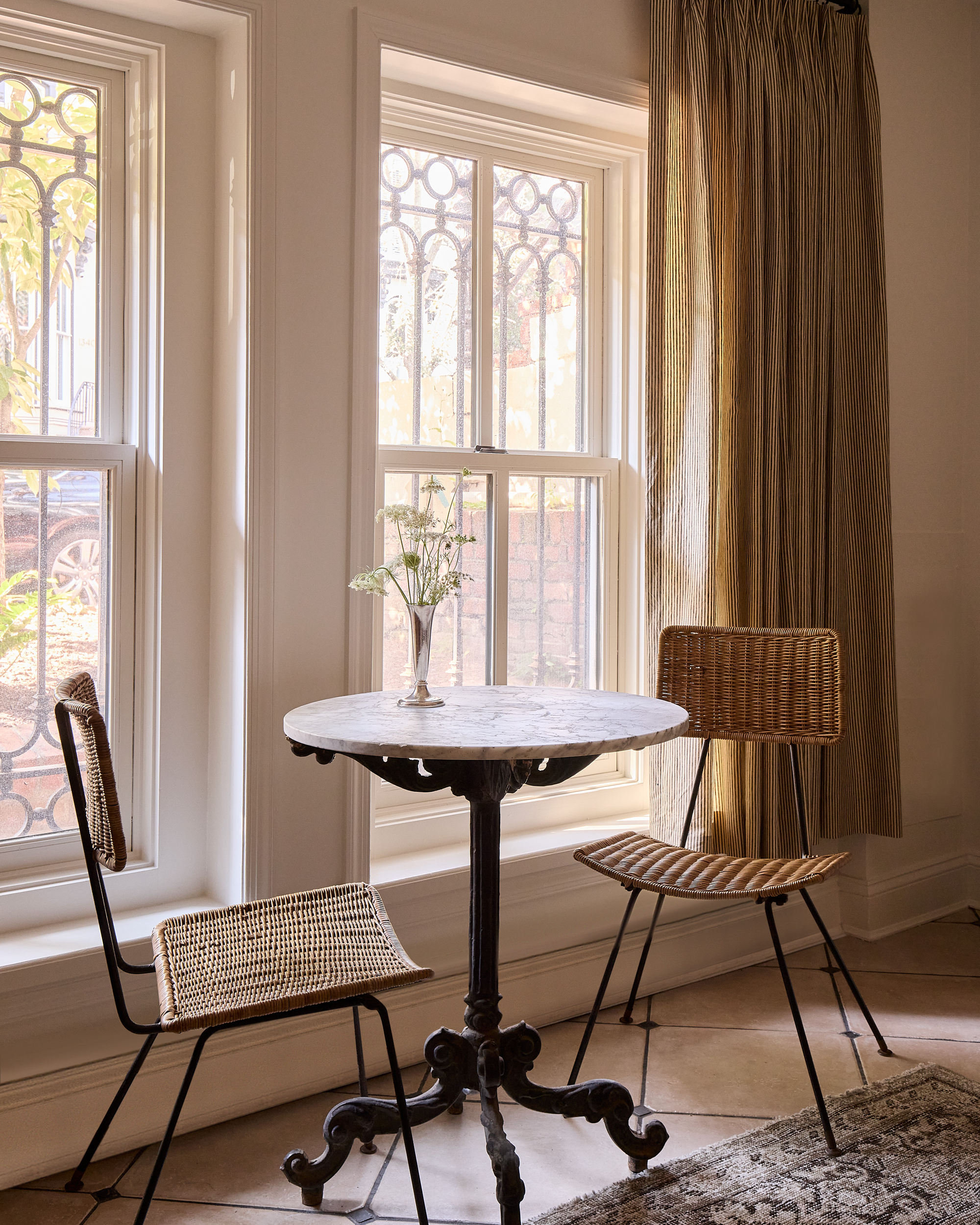 a small bistro dining table and wicker chairs
