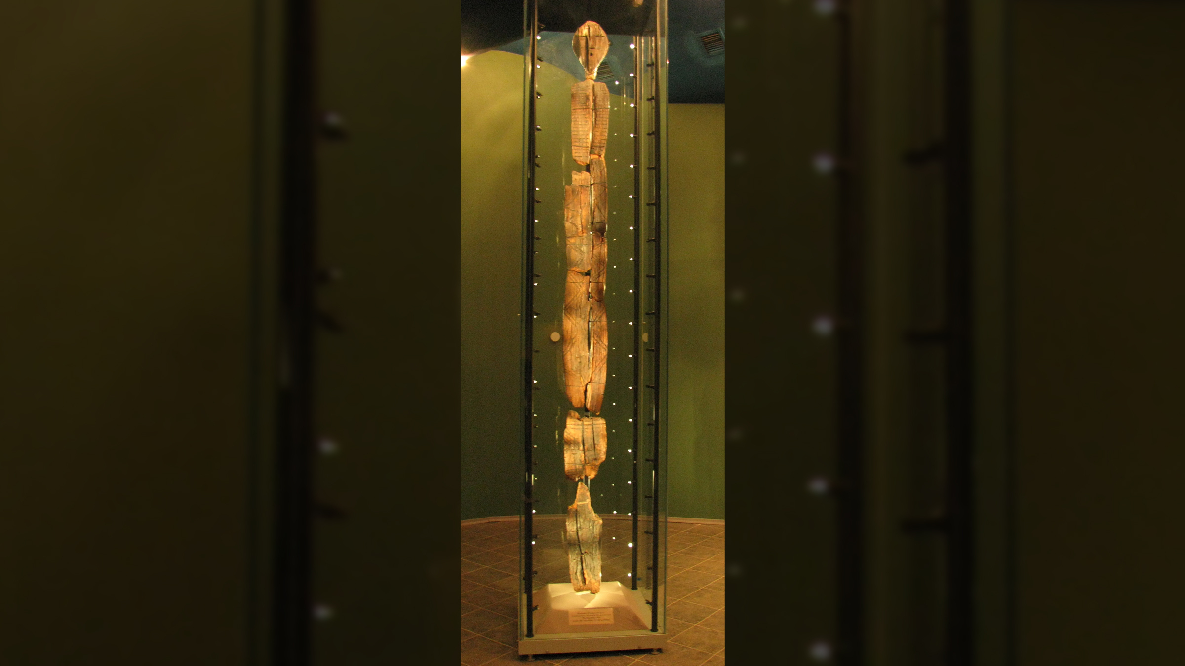 A tall carved statue in a museum