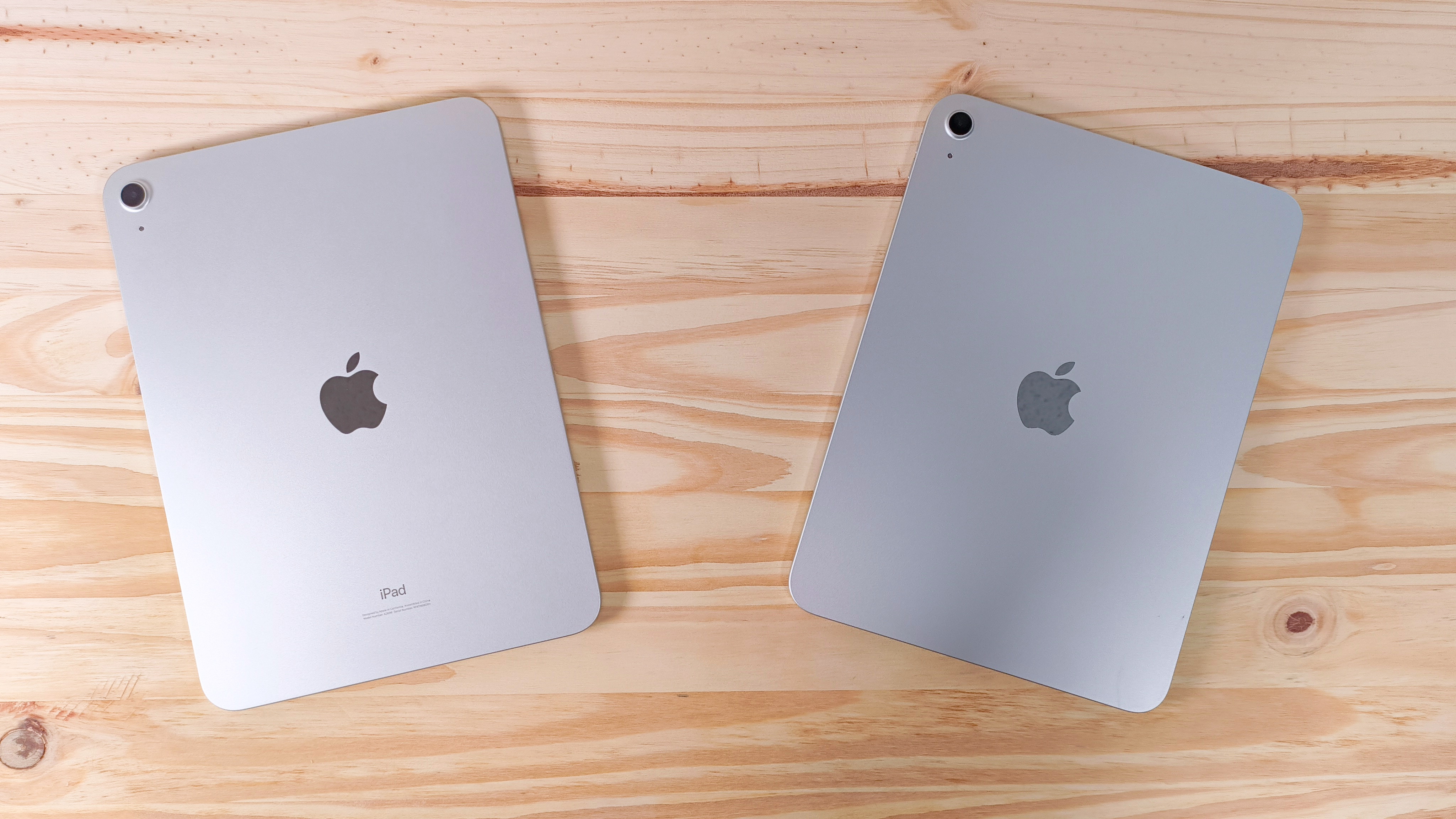 The iPad 10 and iPad 11 face down side by side on a wood table