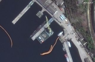 This photo, taken by Maxar Technologies' WorldView-2 satellite, shows missiles being loaded onto a Russian Kilo-class submarine (center, to left of tall yellow tower) in the Black Sea port of Sevastopol on April 29, 2022.