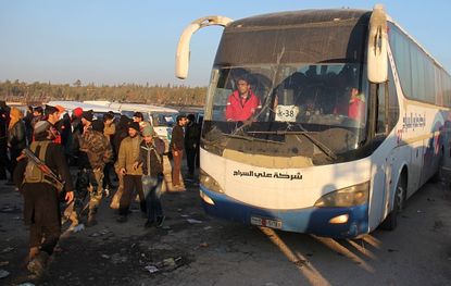 Buses carry evacuees out of eastern Aleppo on Monday.