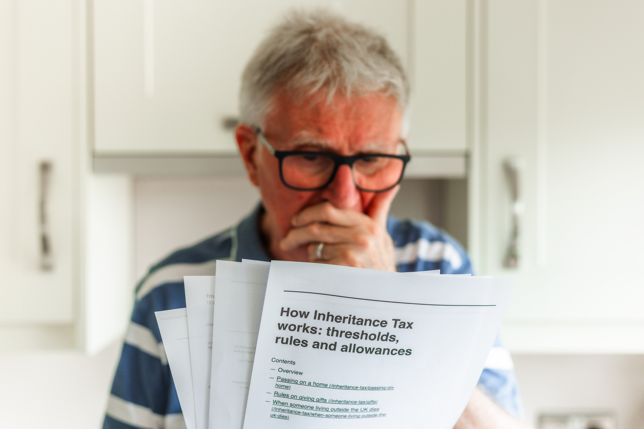 A worried man reading inheritance tax paperwork