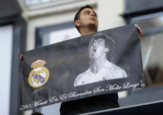 A Real Madrid fan holds a banner with an image and famous quote from club legend Juanito in Los Blancos' Champions League semi-final second leg against Borussia Dortmund in 2013.