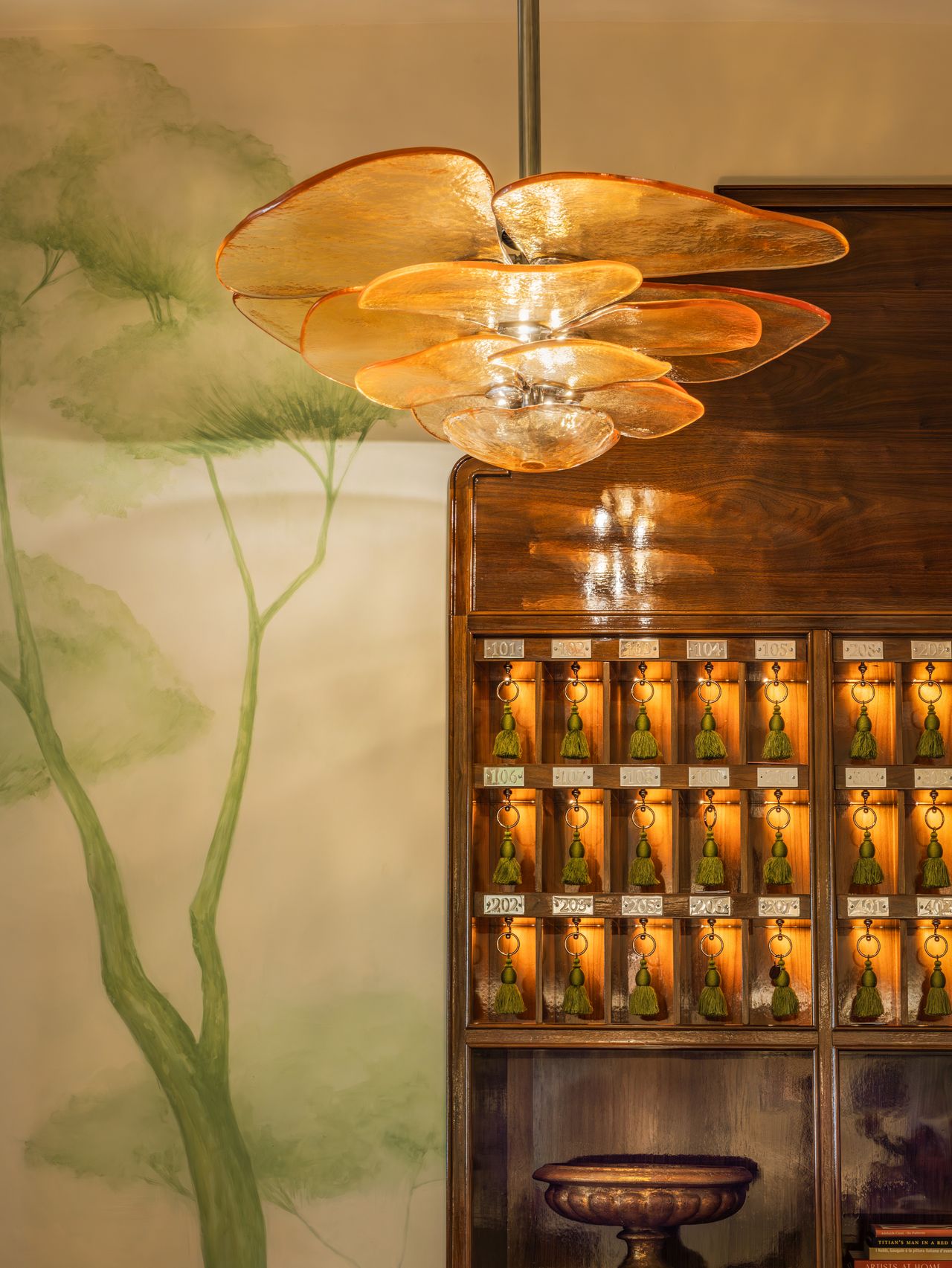 A maximalism-inspired luxury boutique hotel features layered interiors with sculptures, mural-filled walls, and plush furniture.