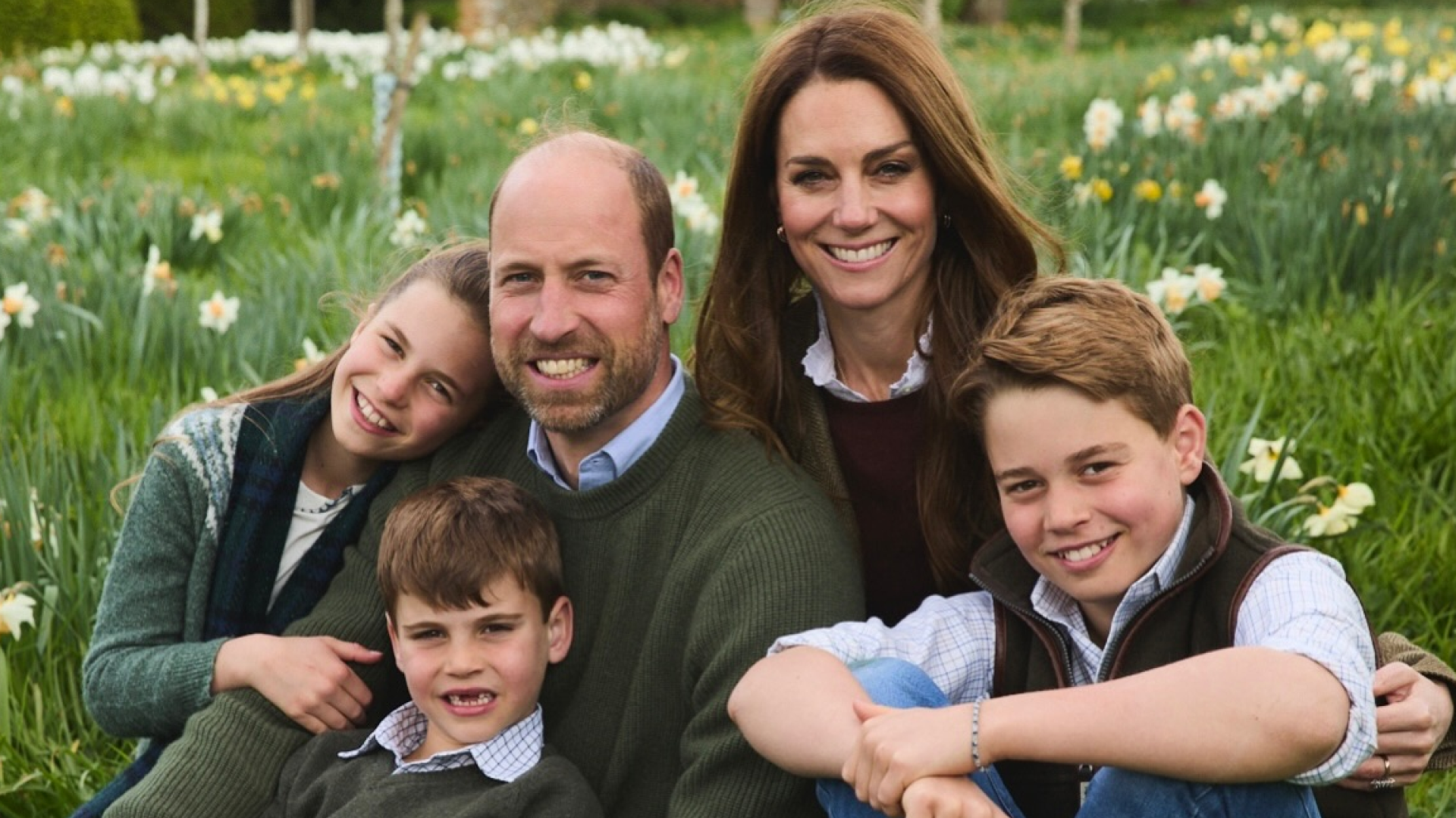 Prince William, Princess Kate, Princess Charlotte, Prince Louis and Prince George sitting in a field of flowers