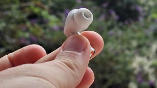 The Samsung Galaxy Buds 3 Pro against a leafy background.