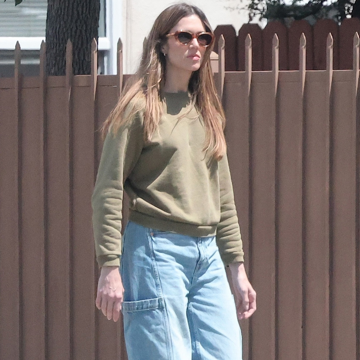 Mandy wears a green sweater and jeans.