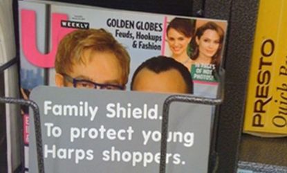 Reportedly, a customer complaint led an Arkansas supermarket to cover Elton John's family photo on US Weekly.