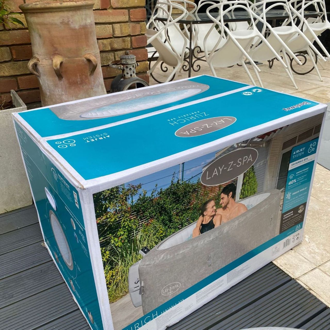 Lay-Z-Spa Zurich in a cardboard box with a picture of the hot tub on, on decking
