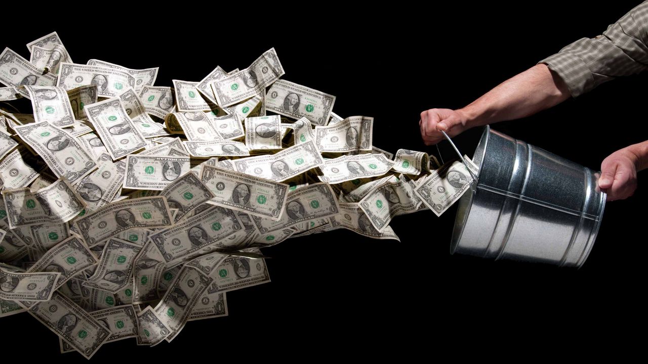 man throwing bucket of cash