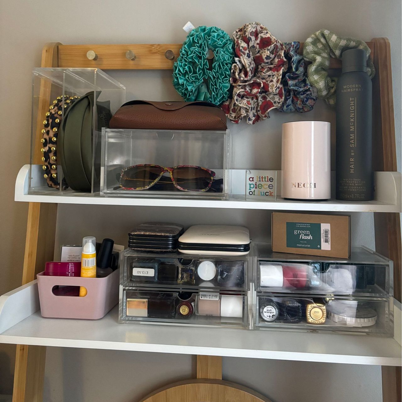 A dressing table covered in accessories that are stored in clear plastic storage boxes