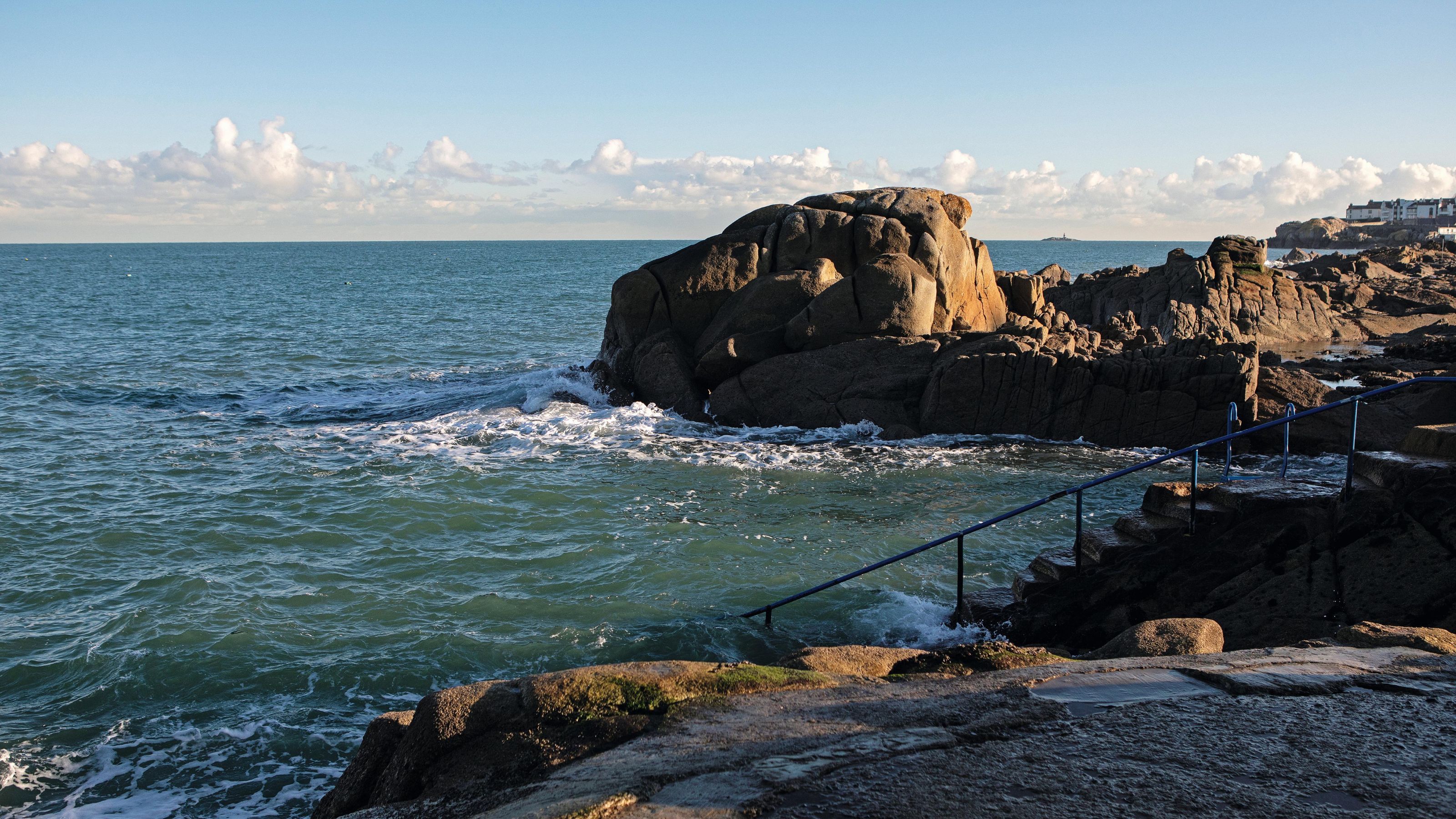 the seaside garden view from a Dublin home with rocks and steps down to the water