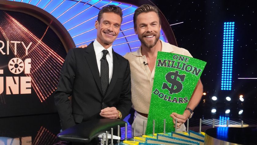 RYAN SEACREST and DEREK HOUGH side by side smiling on the set of Wheel of Fortune.