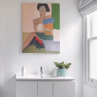 White bathroom with canvas above sink