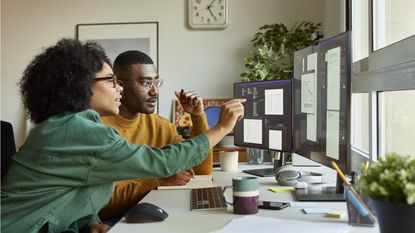 A couple sits in front of a computer while making financial plans for the new year.