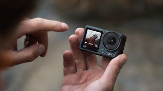 DJI Osmo Action 4 camera in the hand of a mountaineer using the controls