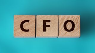 The letters CFO on three wooden blocks on a blue background