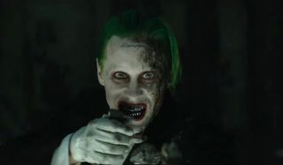 Suicide Squad Joker pulling the pin on a grenade with his teeth
