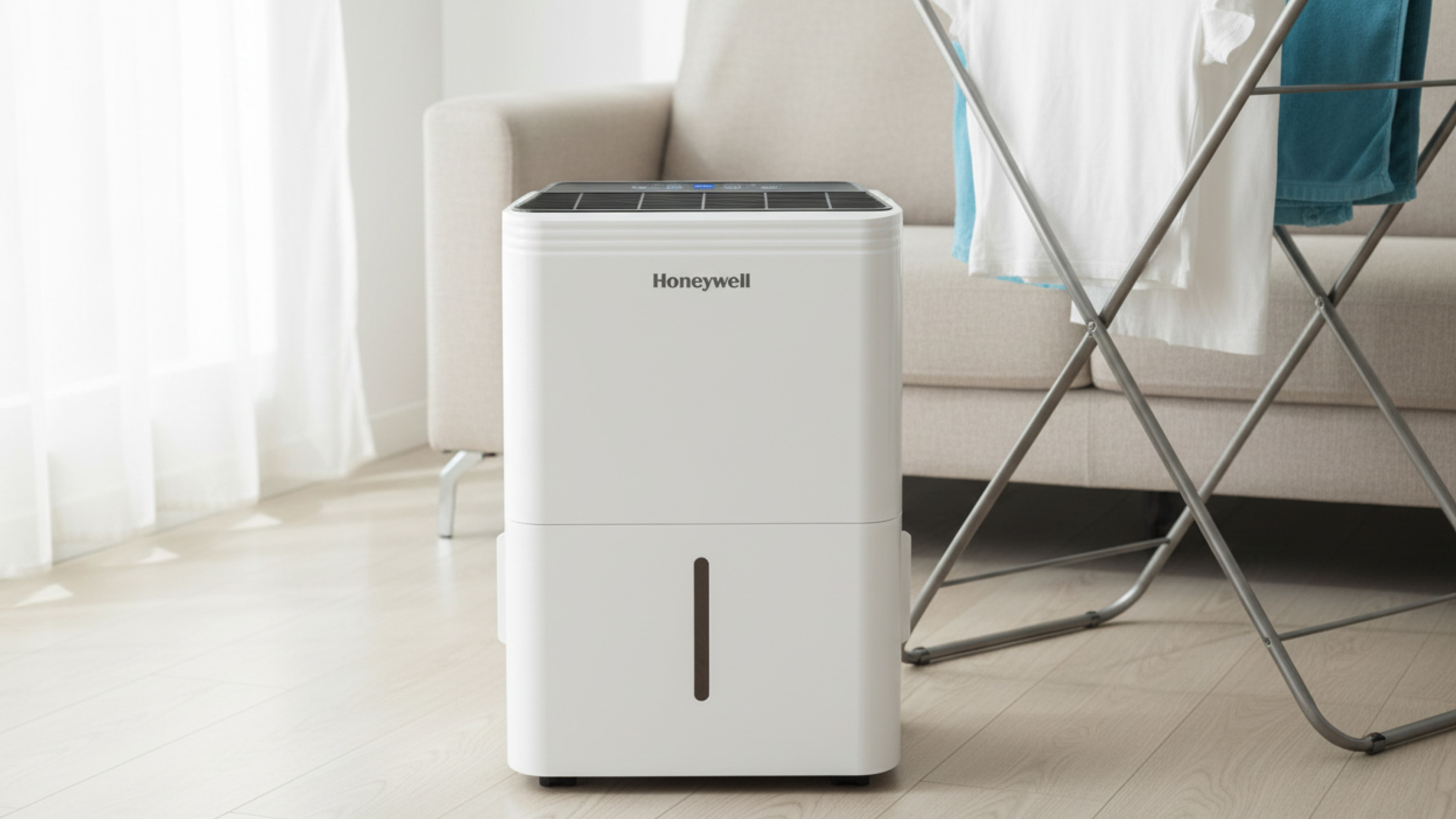Honeywell 12L dehumidifier TPFIT sitting in front of a clothes airer with washing drying in a living room