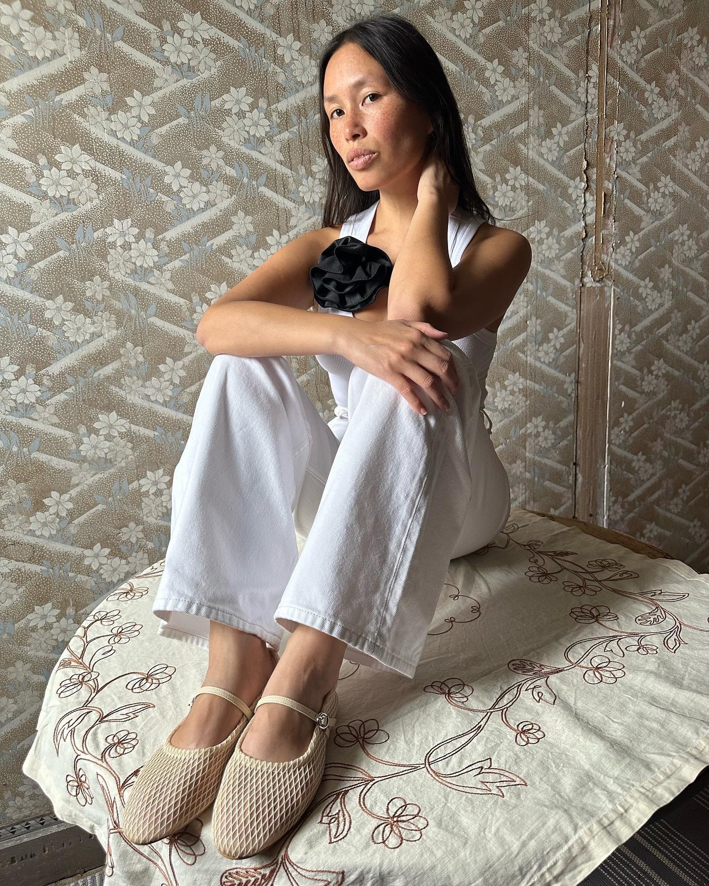 Woman wears white jeans + white flat shoes