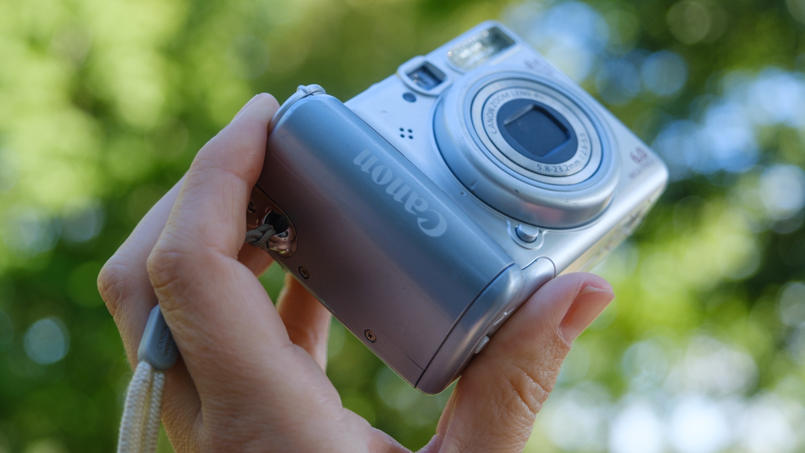The Canon PowerShot A540 held in a person's hands outdoors