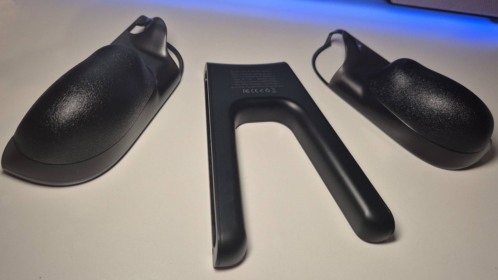 Photo showing the back of the JSAUX Switch 2 Charging Grip on a white desk.