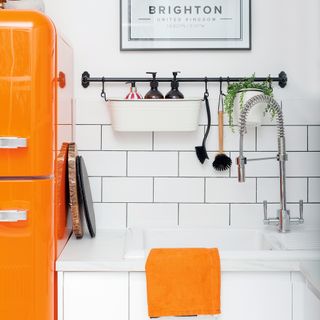White kitchen with metro tiled splashback and hanging rail