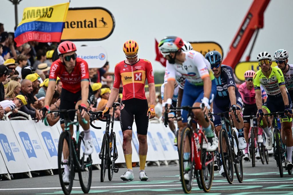 UnoX Pro Cycling Teams Norwegian rider Soren Waerenskjold C walks to the finish line after crashing in the final sprint of the 4th stage of the 110th edition of the Tour de France cycling race 182 km between Dax and Nogaro in southwestern France on July 4 2023 Photo by Marco BERTORELLO AFP Photo by MARCO BERTORELLOAFP via Getty Images