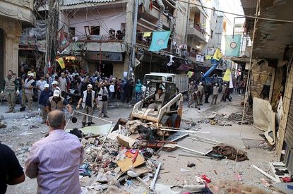 Crews clean up the site of a deadly suicide bombing in Beirut.