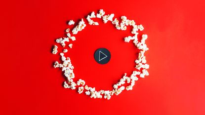 Play button and popcorn on a red background