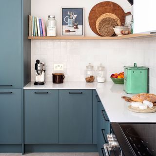Blue painted kitchen cabinets and dark handles, decorated kitchen worktop