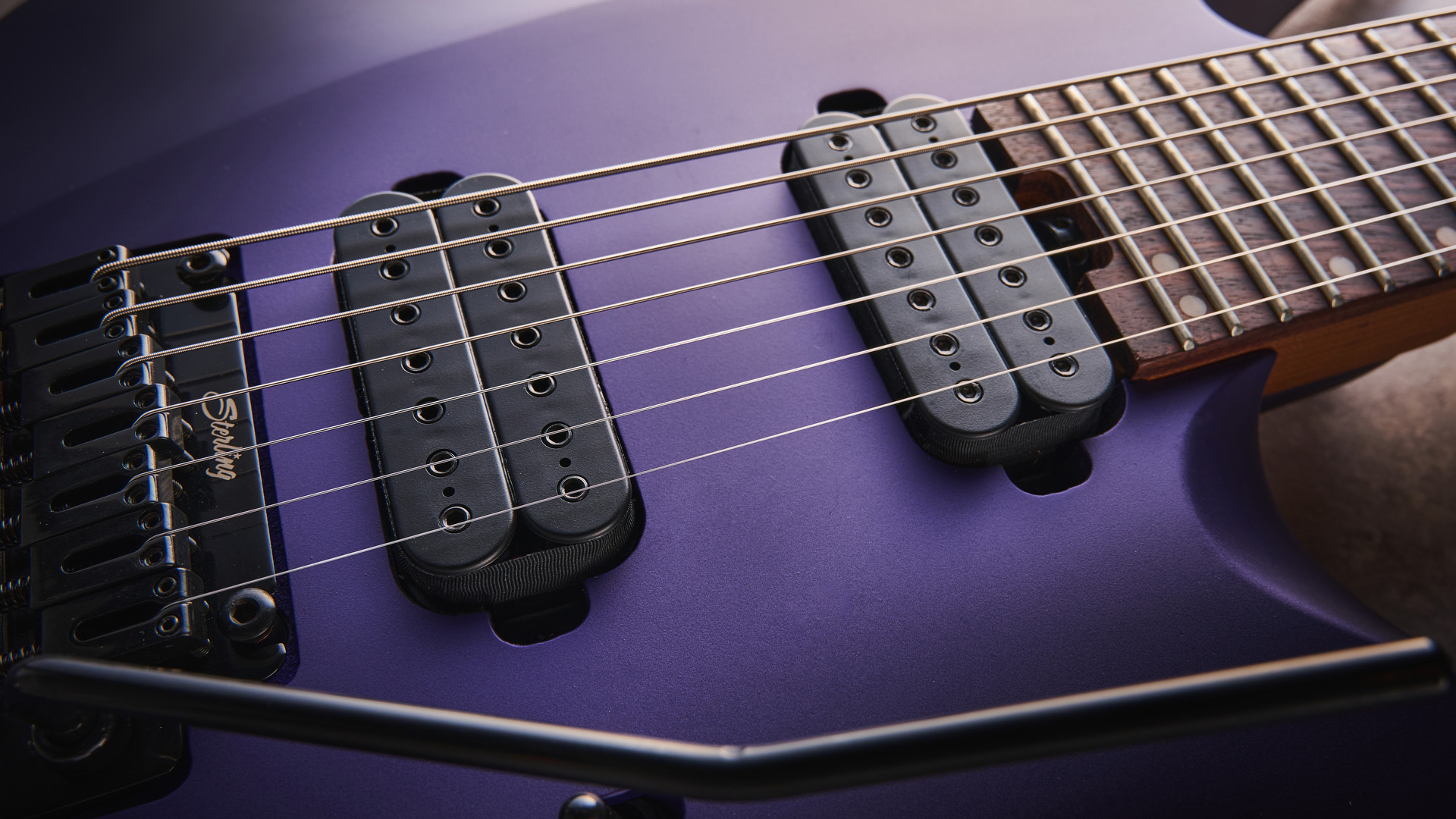 Sterling By Music Man Kaizen 7-string in Firemist Purple Satin, shot in close-up.