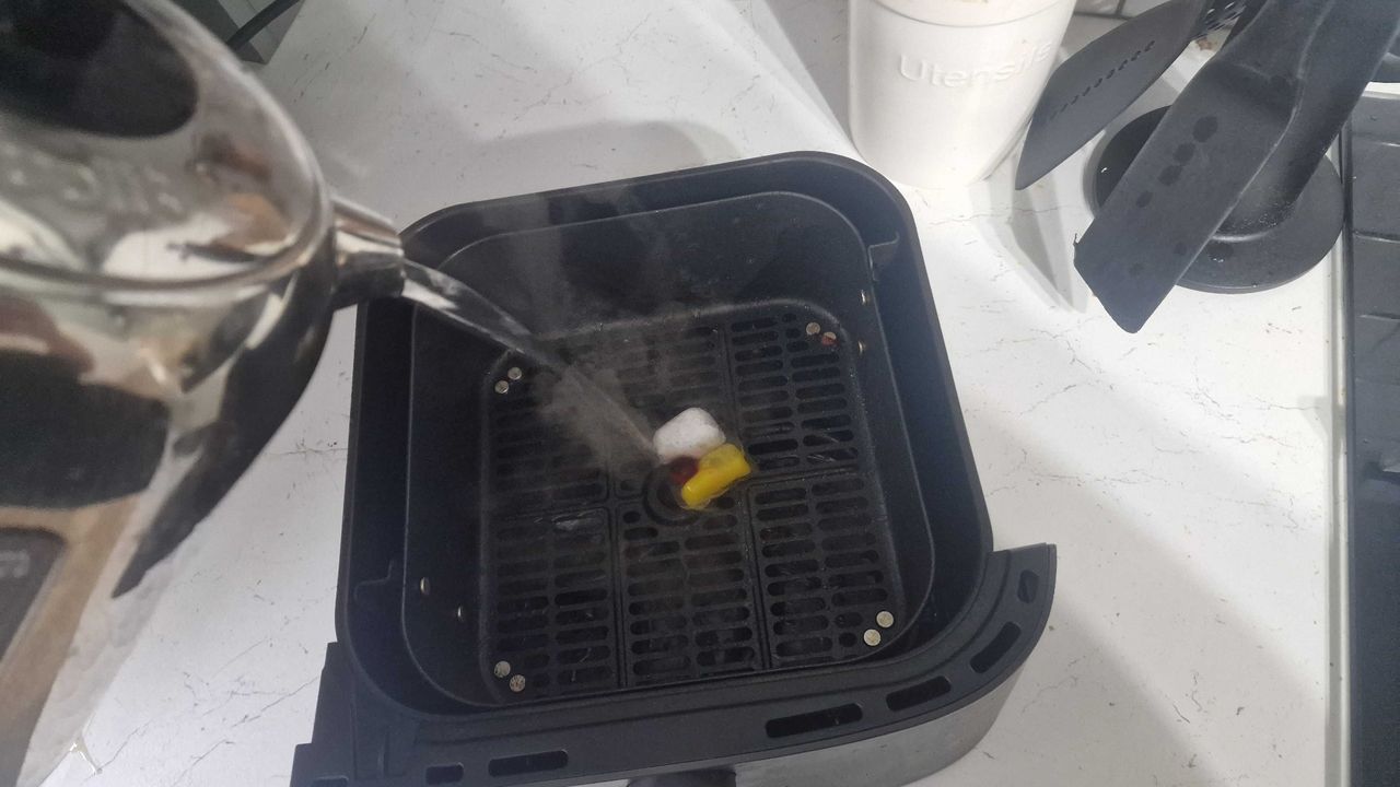 Placing a dishwasher tablet in the air fryer basket