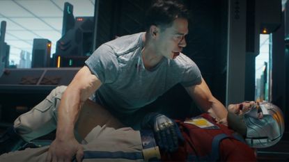 Peacemaker holding the bloody corpse of his own alt-reality doppelganger