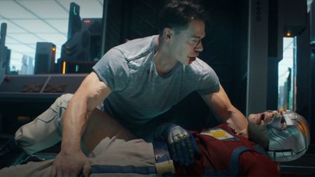 Peacemaker holding the bloody corpse of his own alt-reality doppelganger