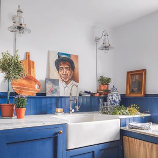 Utility room with bright blue cabinets, open shelving and butler sink