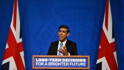 Rishi Sunak gives speeech in front of a lecturn that reads, 'long-term decisions for a bright future'