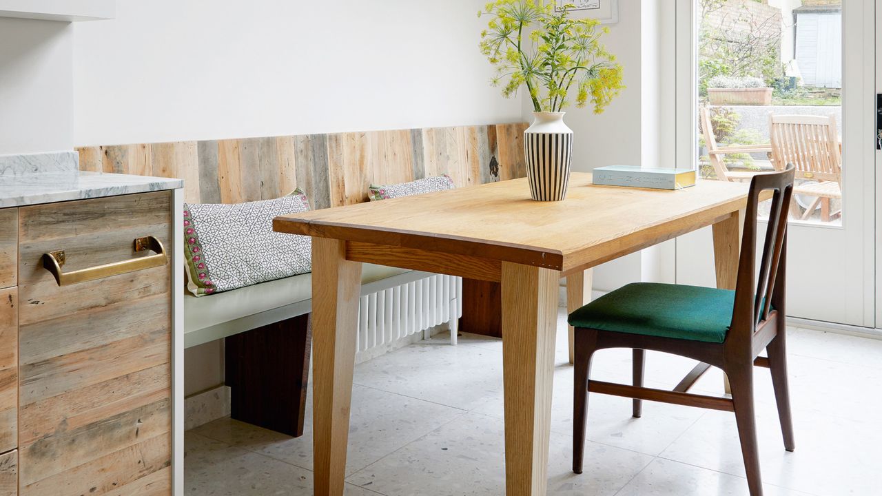 white kitchen diner with porthole and skylight, wooden cabinets, wooden backsplash, wooden table and dark wood dining chair 