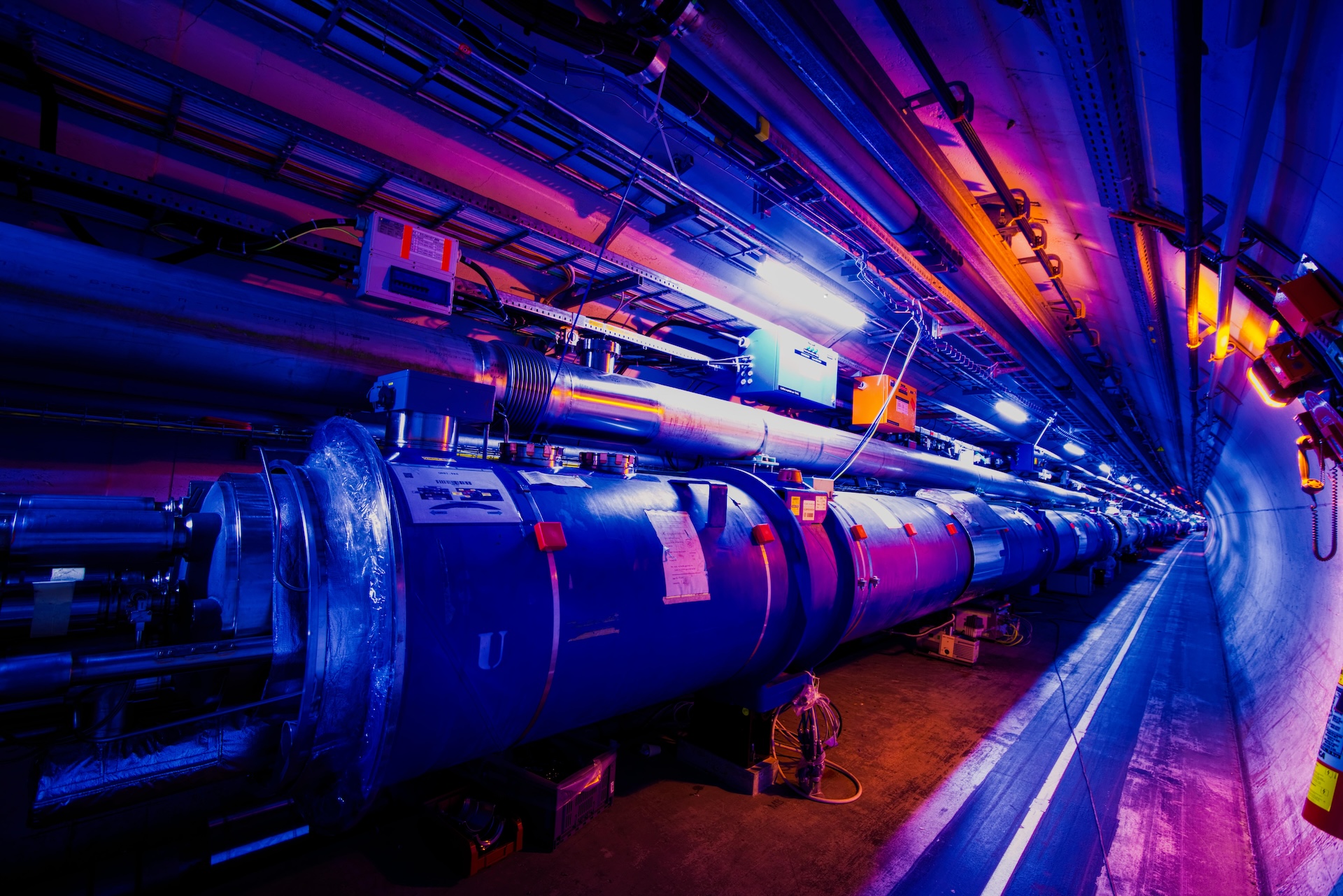 A photo of the LHC tunnel bathed in purple light