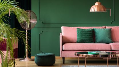 Image of a green room with a pink sofa illustrating the forest green color trend